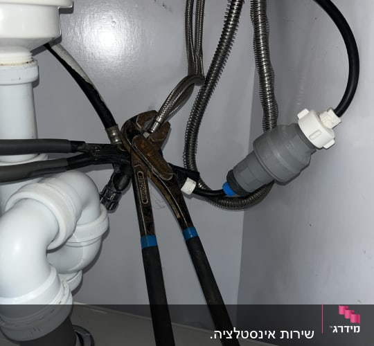 עבודת אינסטלציה וחיבור צינורות גמישים לברז מתחת לכיור